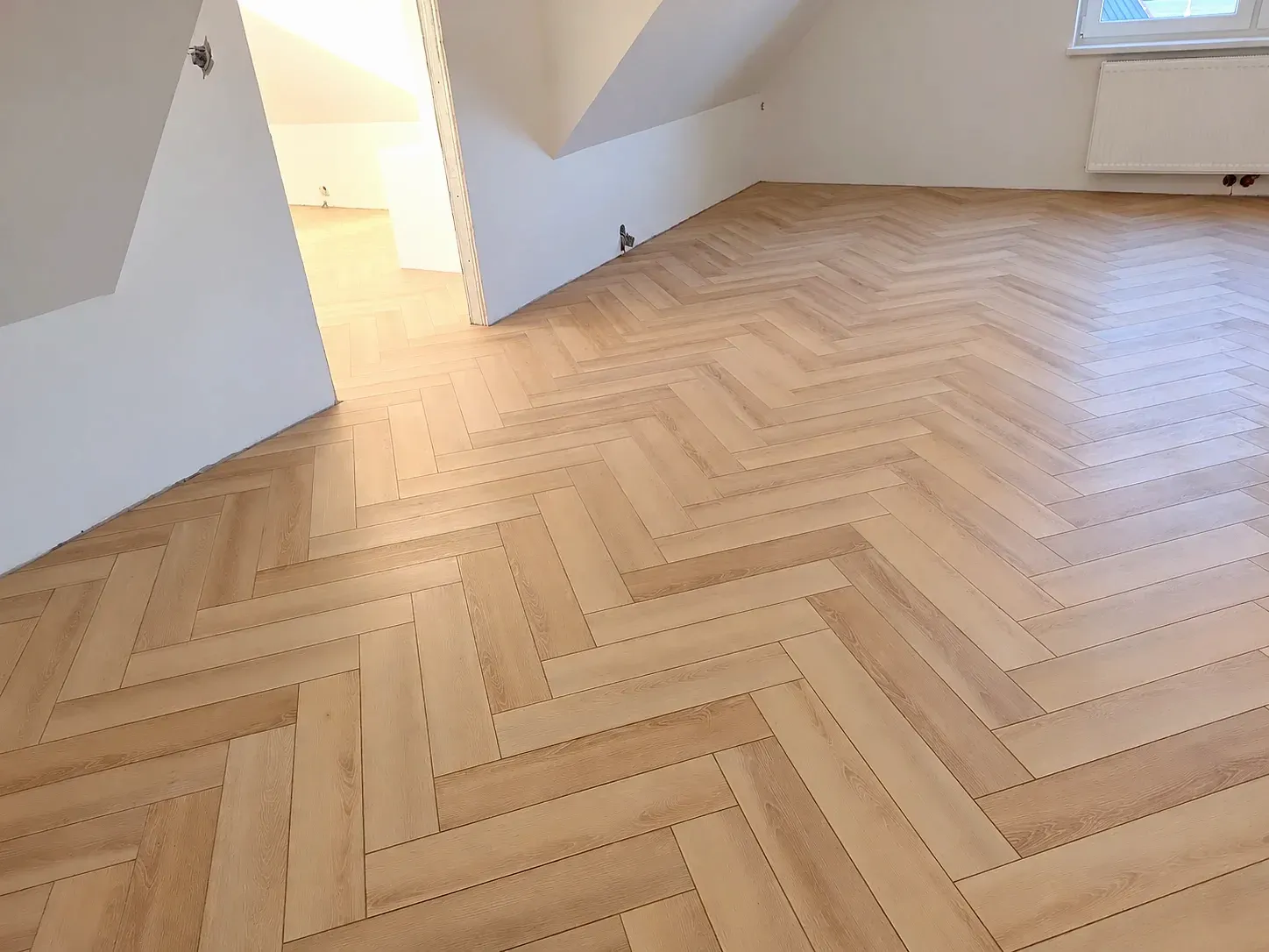 Jodełka prowadzona jednym wzorem przez drzwi do kolejnego pomieszczenia